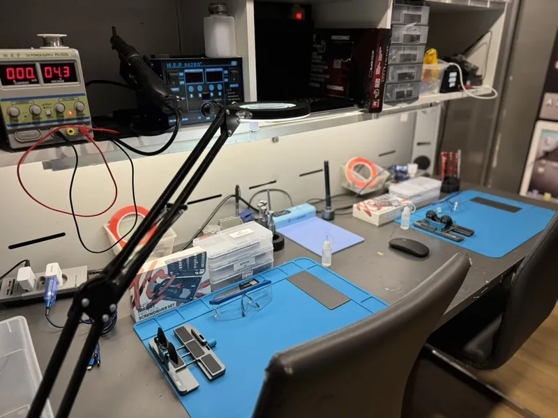 Établi de réparation de smartphones avec outils de précision, atelier de Mantes-la-Jolie
